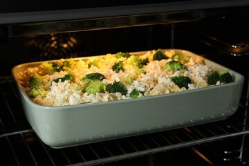 Baking dish with uncooked pasta casserole in oven, closeup