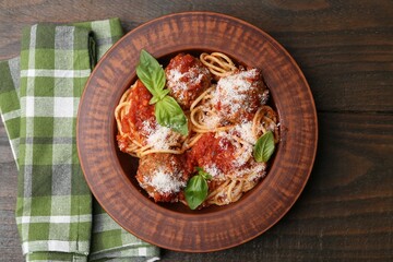 Delicious pasta with meatballs, cheese and basil on wooden table, top view