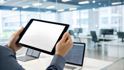 Businessman using a digital tablet with blank screen in a modern open office setting