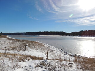 Winter landscape at the lake with snow and trees