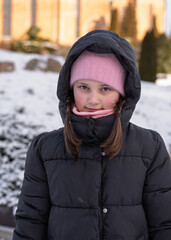 Portrait of a 10-year-old girl in winter with a hat and hood
