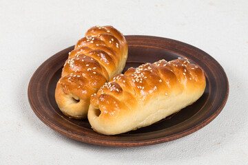 Two sausages in the dough. On a plate. White background