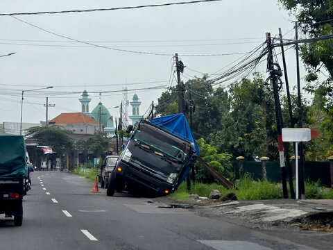 traffic accidents, trucks overturned on the side of the road because the road collapsed