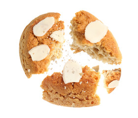 Yummy nut cookie with almond petals in air on white background