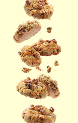 Yummy nut cookies in air on beige background