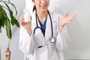 薬の説明をする白衣姿の若いアジア人女性