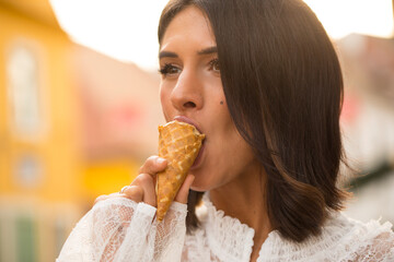 Beautiful happy woman licks ice cream during a hot summer day. Happy day. Summer time. Photo. 