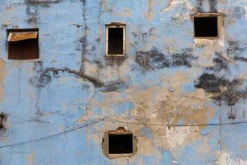 Cuba, Havana, old Havana wall, peeling blue paint.  Vacant windows. 2016-03-25
