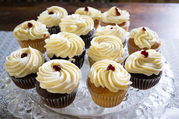 Assorted Cupcakes with Creamy Swirl Frosting on a Glass Serving Plate