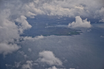 Iceland from airplane through clouds. Aerial scenic view of Iceland landscape. Travel vacation concept. Europe.