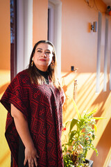Latin tourist wearing traditional poncho exploring a hotel during vacation