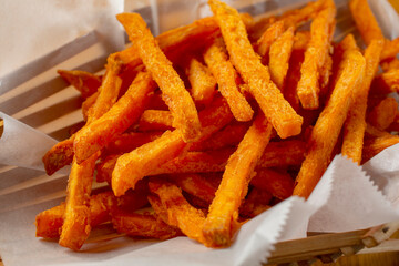 A closeup view of a basket of sweet potato fries.