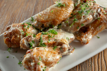 A view of a plate of creamy garlic chicken wings.