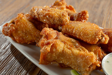 A view of a plate of deep fried chicken wings.