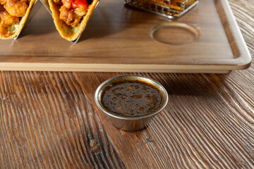 A view of a metal condiment cup of salsa macha.