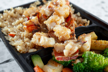 A closeup view of a grilled lobster bowl.