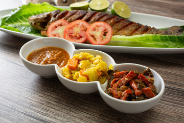 A view of a variety of condiments to do go with fish tibs.