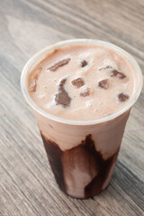 A view of a iced chocomil, in a plastic cup.