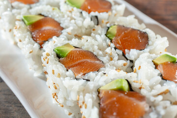 A closeup view of a salmon avocado roll.