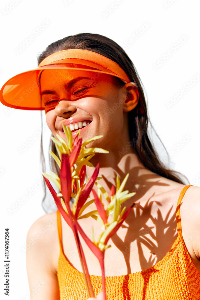 Poster Smiling young woman wearing an orange visor, holding flowers, showcasing joy and summer vibes against a bright white background.