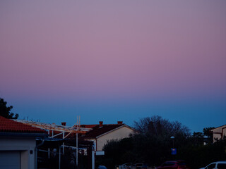 Beautiful color transitions in the sky at dusk after sunset. Natural beauty in nature. Landscape with roofs of city houses. Natural gradient background. Pula, Croatia - January 3, 2025