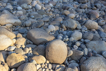 Rocks and pebbles on the beach in the evening.