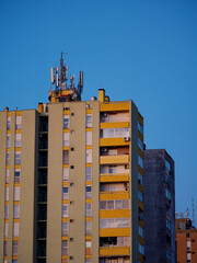 Cellular antennas and transmitters on roof of residential building. Radio transmitting equipment and communication lines on roof. 5G antennas. Evening sunset sky. Pula, Croatia - January 3, 2025