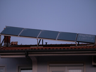 Solar panels installed above the tiled roof. Ventilation pipe with rotating nozzle. Solar energy concept. Pula, Croatia - January 3, 2025