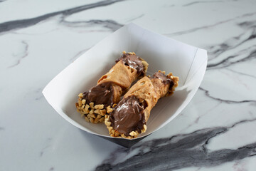 A view of two cannoli desserts.