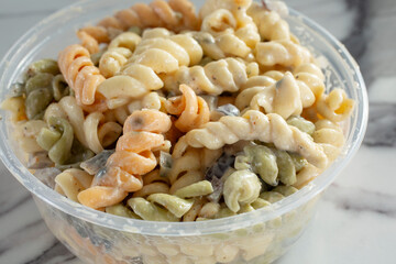 A closeup view of a container of pasta salad.
