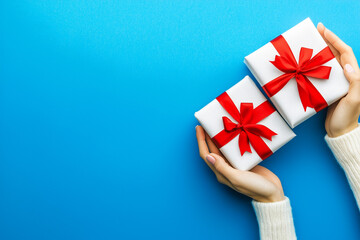 Fototapeta premium Hands holding gift wrapped with ribbon isolated on a color background