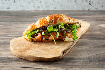 A view of a smoked salmon croissant sandwich.