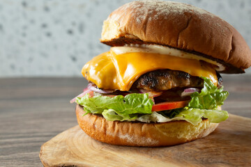 A closeup view of a cheeseburger.