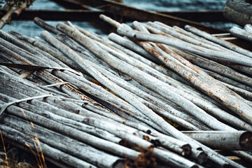 A collection of weathered wood sticks is thoughtfully arranged and piled up by the shoreline