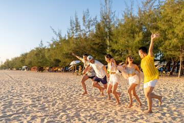 Happy man and woman travel the sea on summer beach holiday vacation. Group of Asian people friends enjoy and fun outdoor lifestyle travel nature running and playing together at tropical island beach.