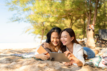 Happy woman using mobile phone during travel nature the sea on summer beach holiday vacation. Attractive girl enjoy and fun outdoor lifestyle using smartphone taking selfie with friend at the beach.