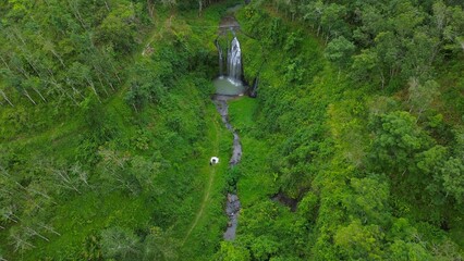 Drone view of Curug Gong Banyumas Central Java Indonesia, a waterfall amidst vegetation and green trees in the middle of the forest
