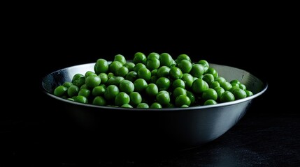 Freshly shelled green peas in a steel bowl showcasing vibrant color and nutrition on a dark background for food and health themes.