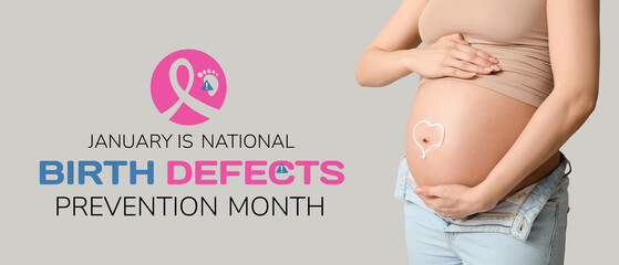 Young pregnant woman with heart made of cream on her belly against grey background