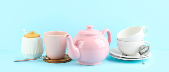 Stylish tea set on blue background