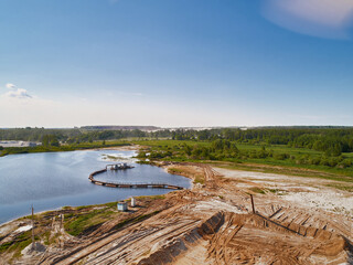 Suction tube dredger in sand mining quarry on sunny day