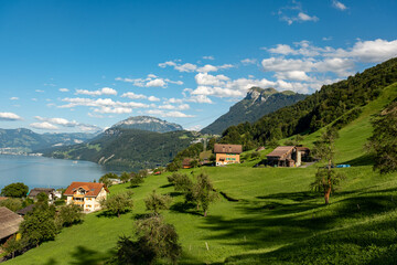 Fototapeta premium Alpine village in mountains. Switzerland lake rural landscape. Switzerland Alps and Lake. Switzerland traveling, hiking, vacation. Mountains in the Swiss Alps. Landscape with green fields.