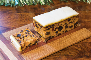 Luxury Iced Rich Fruit Cake with Brandy, full cake and slice on wooden board