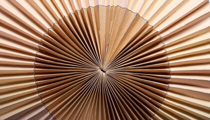 Close-up of a meticulously folded paper fan, showcasing its intricate radial pattern and warm, earthy tones.