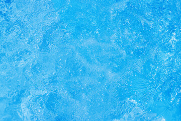 Obraz premium Serene blue water surface with gentle ripples and a soft sun glow