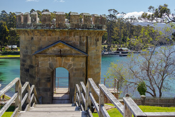 Port Arthur historical site in Tasmania, Australia, with stone tower, scenic waterfront, and lush green surroundings