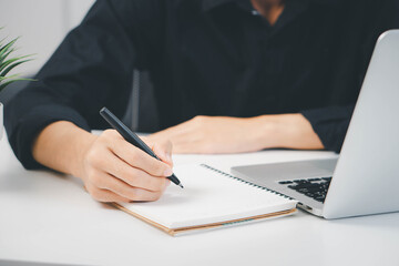 Male hand taking notes on the notepad. businessman working at work table, checklist writing planning investigate enthusiastic concept. focus on man hand holding pen, putting signature at official pape