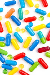 A colorful assortment of capsules and gel pills scattered on a white surface.