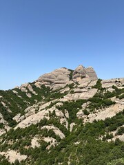 Fototapeta premium This stunning image captures the unique landscape of Montserrat Mountain Natural Park in Catalonia, Spain. The photo showcases the striking rock formations of the mountain