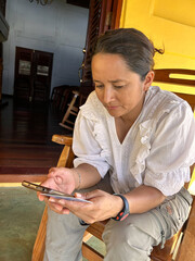 a woman shops with her credit card in hand, shopping on a mobile app, from the comfort of her home...
